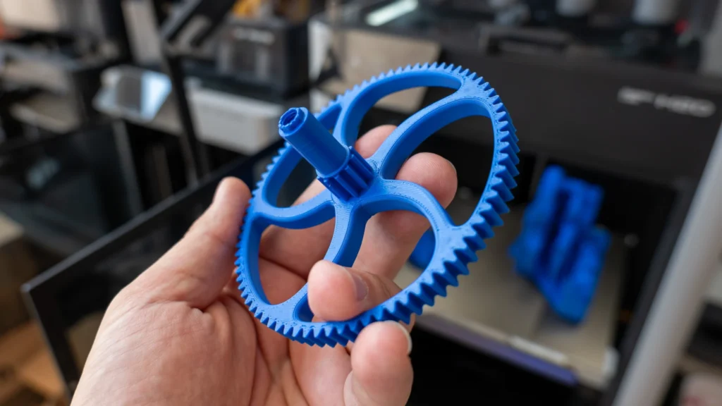 ASA ili PETG: Koje su razlike 2 Ruka drži plavi 3D-ispisani dio