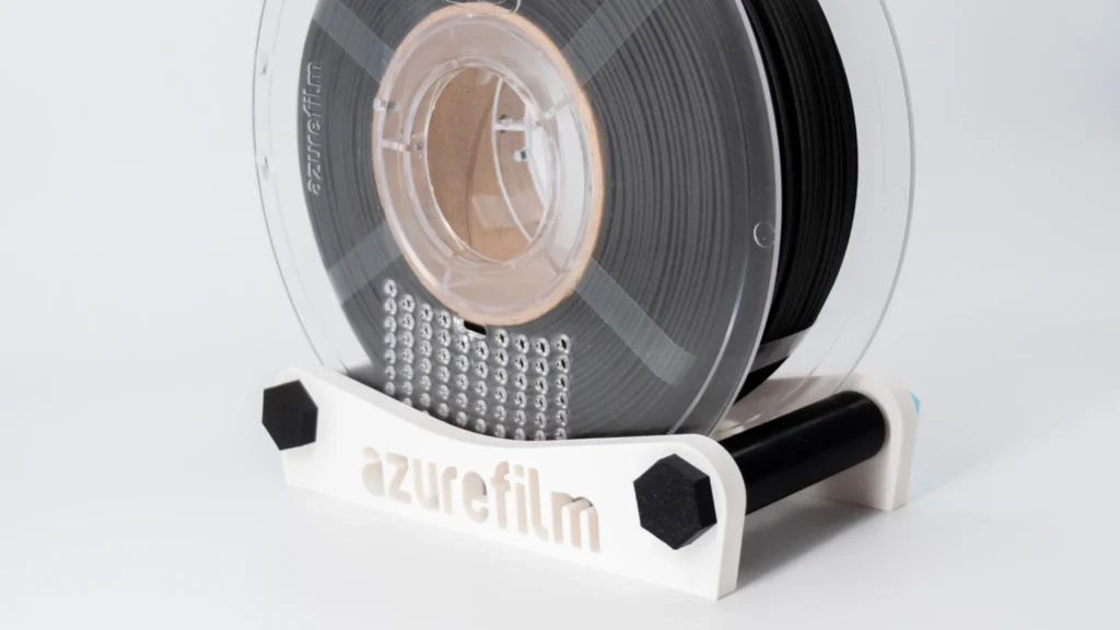 PLA ili PLA+: Koje su razlike 6 Kolut PLA+ filamenta na 3D-ispisanom držaču