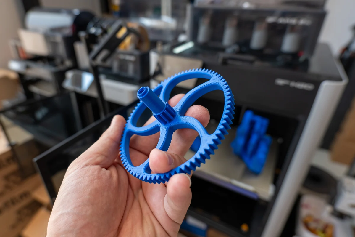 Enter B2B 10 Hand holding a blue 3D-printed gear